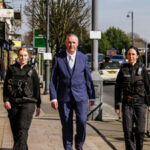 Clive Grunshaw walking with officers