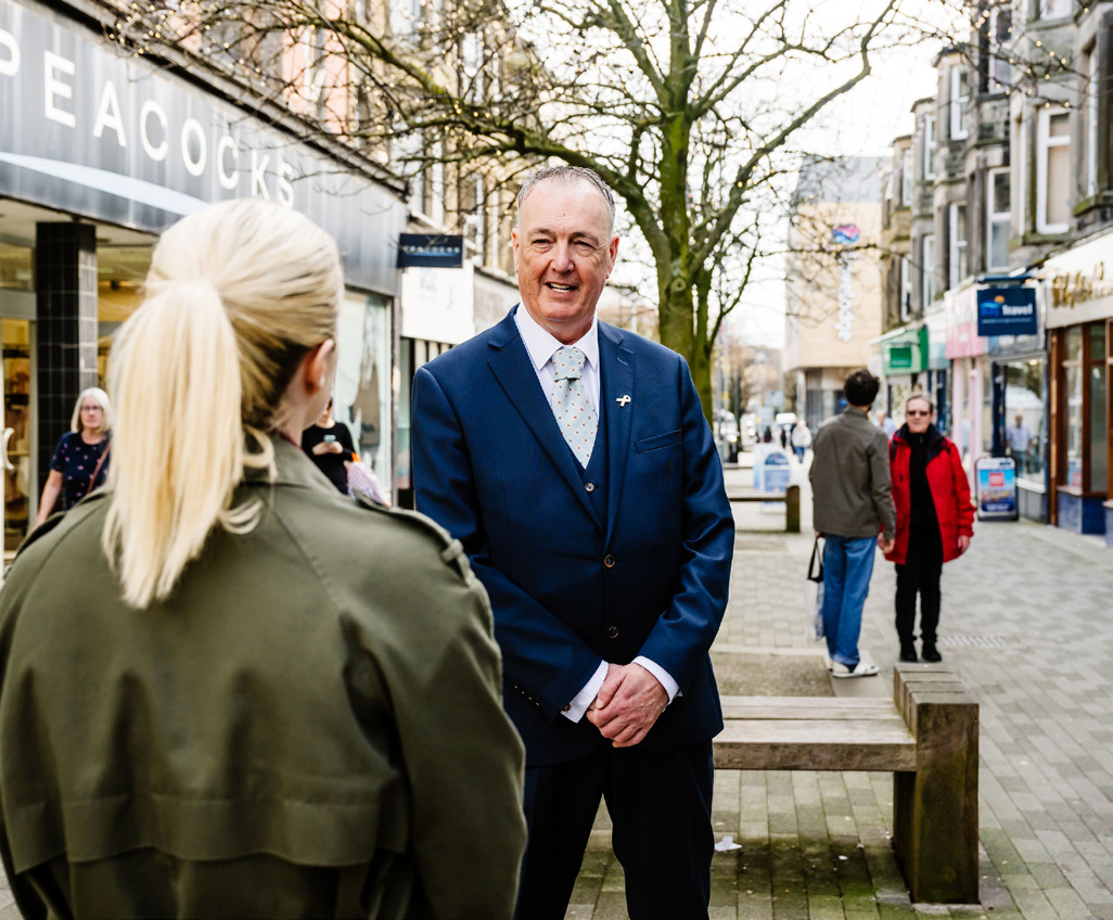Clive Grunshaw with a member of the public in a town center